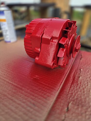 Delco 10SI one wire alternator painted red on a workbench